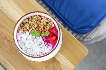 Dragon fruit smoothie bowl with granola and sliced almonds, healthy delicious breakfast option