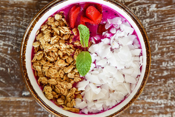 Dragon fruit smoothie bowl with granola and sliced almonds, healthy delicious breakfast option