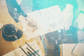 DNA theme hologram over woman's hands writing background. Concept of education. Double exposure