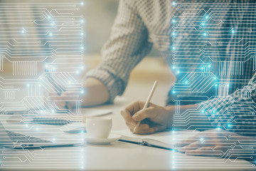 Obraz premium Technology theme hologram with man working on computer on background. High tech concept. Double exposure.