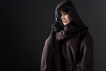 woman in death costume holding gun isolated on black