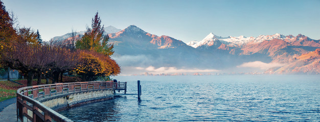 Misty morning panorama of Zell lake. Picturesque autumn view of Austrian Alps, with Grossglockner...