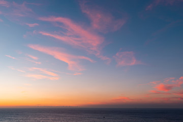 Naklejka na ściany i meble Colorful sunrise sky over the ocean horizon.