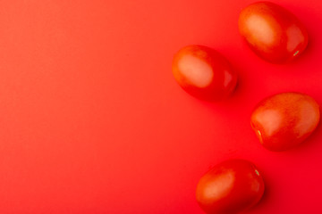 red tomatoes on a red background, creative concept, with space