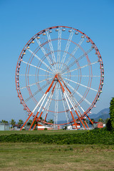 Ferris wheel over blue sky background, close up