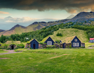 Fototapeta na wymiar Typical view of Icelandic turf-top houses. Colorful summer morning in the Skogar village, south Iceland, Europe. Traveling concept background. Instagram filter toned.