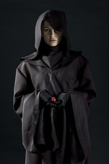woman in death costume holding dice isolated on black
