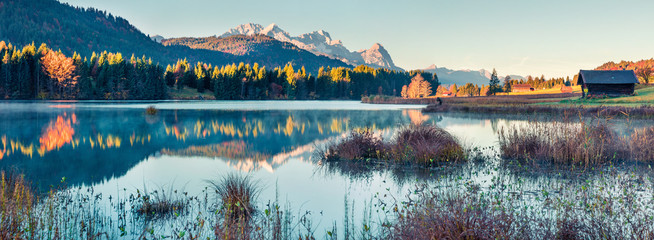 Marvelous morning panorama of Wagenbruchsee (Geroldsee) lake with Zugspitze mountain range on background. Beautiful autumn view of Bavarian Alps, Germany, Europe. Instagram filter toning. - obrazy, fototapety, plakaty