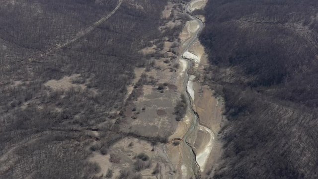 Polluted winding river stream from above 4K aerial video