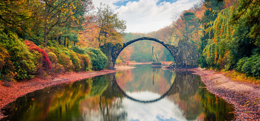 Unglaubliche Morgenszene von Azaleen- und Rhododendronpark Kromlau, Deutschland, Europa. Tolles Herbstpanorama der Rakotzbrücke (Rakotzbrücke, Teufelsbrücke). Hintergrund des reisenden Konzepts.