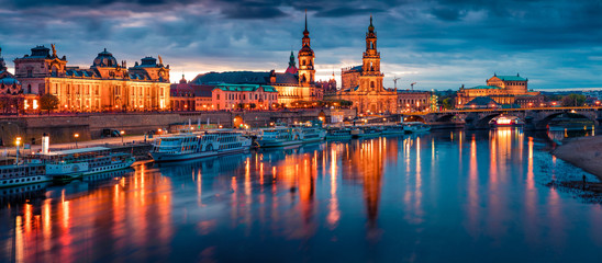 Fototapeta na wymiar Fantastic evennig panorama of Cathedral of the Holy Trinity or Hofkirche, Bruehl's Terrace or The Balcony of Europe. Dramatic autumn sunset on Elbe river in Dresden, Saxony, Germany, Europe.