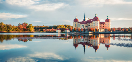 Exciting morning panorama of Moritzburg Baroque palace surrounded by a lake. Great autumn sunrise...