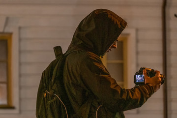 The guy in the hood in the jacket takes off in the evening on the camera