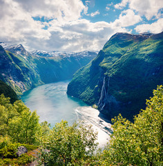 Sunny summer scene of Sunnylvsfjorden fjord, Geiranger village location, western Norway. Aerial view of famous Seven Sisters waterfalls. Beauty of nature concept background.