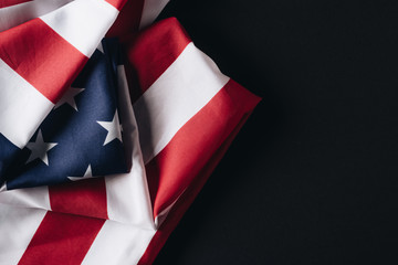 folded united states of america national flag isolated on black, memorial day concept