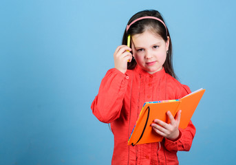 Education in reading. Cute little girl learn reading and writing in exercise book. Adorable small...