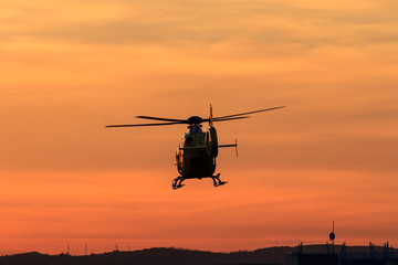 Fototapeta na wymiar Silhoutte of a flying helicopter in backlight of dusk in Vienna, Austria