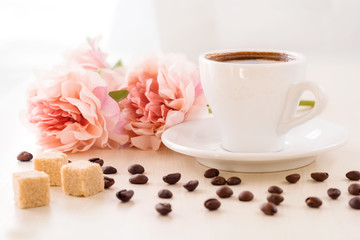 Breakfast in pastel colors. Cup of coffee standing on the table with coffee beans scattered around...