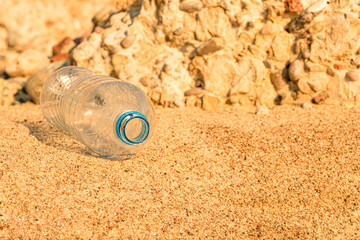 Fototapeta na wymiar water flows out of a plastic bottle on the sea sand. water saving. last water drop .