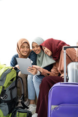 Fototapeta na wymiar muslim asian woman friend sitting in airport terminal and using tablet
