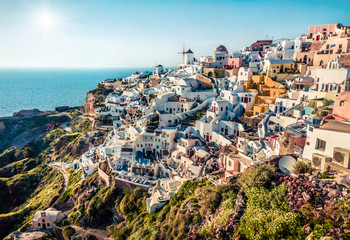 Sunny morning view of Santorini island. Picturesque spring scene of the famous Greek resort Oia,...