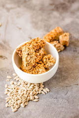 Gozinaki bar of seeds on a gray background. Delicious oriental sweets from the seeds of sunflower, sesame covered with honey with shiny glaze. Macro Country Style.Selective focus