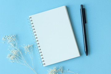 notebook and pen on blue background