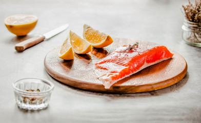Raw salmon fish filet with lemon and spices. On a wooden background.