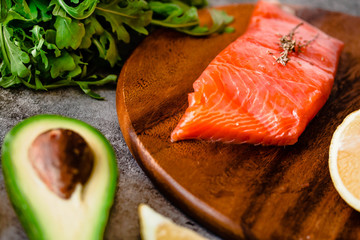 Portion of wild salmon fillet with aromatic herbs, spices, avocado and lemon- healthy breackfast,...