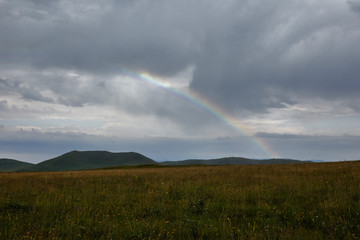 Naklejka na ściany i meble rainbow on a background of clouds in the mountains