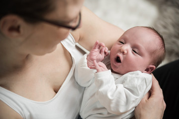 Neugeborenes Baby auf Mutters Arm