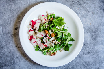 Fresh salad of cucumbers, radishes and herbs. Top view. Spring food concept.