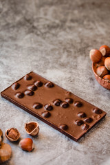 Homemade hazelnut chocolate bar. Nuts and chocolate background. Ingredients for cooking homemade chocolate sweets. Confectionery and sweets concept