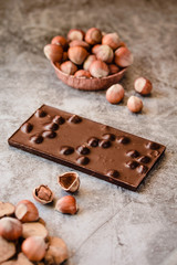 Homemade hazelnut chocolate bar. Nuts and chocolate background. Ingredients for cooking homemade chocolate sweets. Confectionery and sweets concept
