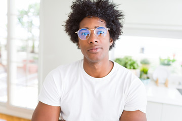 African American man wearing glasses Relaxed with serious expression on face. Simple and natural with crossed arms