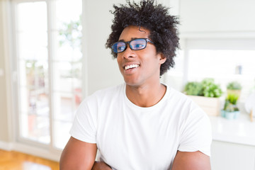 African American man wearing glasses smiling looking side and staring away thinking.