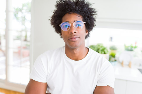 African American man wearing glasses Relaxed with serious expression on face. Simple and natural with crossed arms