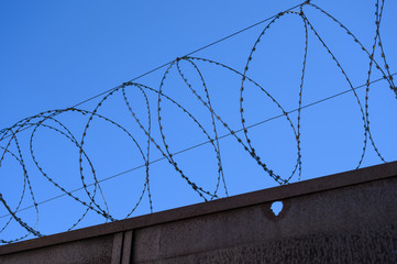 Barbed wire on fence with sky. Selective focus.