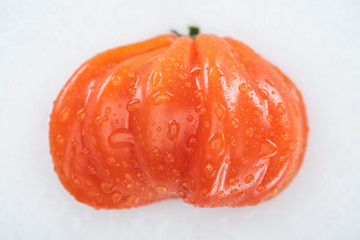 top view of wet red ripe tomato with water drops isolated on white
