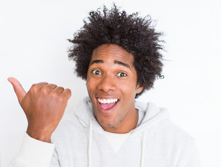 African American man over white isolated background pointing and showing with thumb up to the side with happy face smiling