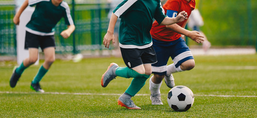 Children Play Football Tournament Game. Young Boys Running and Kicking Football Ball on Grass Sports Field