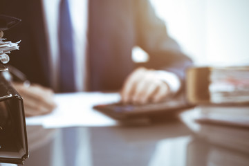 Binders with papers waiting to be processed with businessman or bookkeeper back in blur. Accounting planning budget. Audit, insurance  and business concept