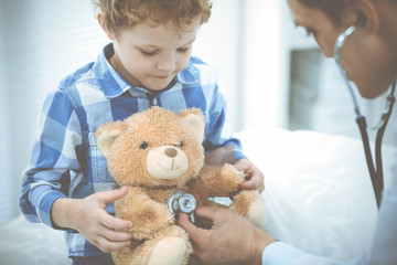 Doctor and patient child. Physician examining little boy. Regular medical visit in clinic. Medicine and health care concept