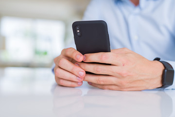 Close up of man hands using smartphone and smiling