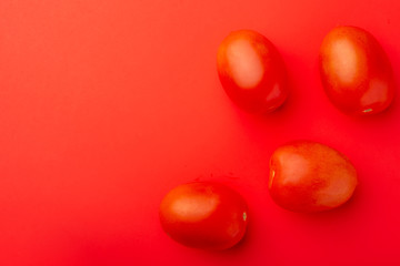 red tomatoes on a red background, creative concept, with space