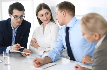 Fototapeta premium Grupa ludzi biznesu, omawiając pytania na spotkaniu w nowoczesnym biurze. Menedżerowie podczas negocjacji lub burzy mózgów. Praca zespołowa, partnerstwo i koncepcja biznesowa