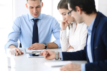 Obraz premium Group of business people discussing questions at meeting in modern office. Managers at negotiation or brainstorm. Teamwork, partnership and business concept