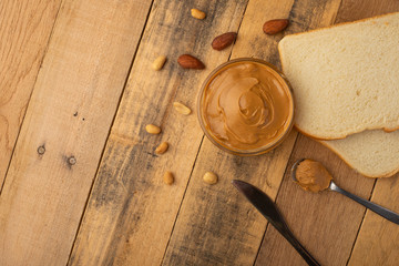 peanut butter, toast and nuts on a wooden texture, top view, breakfast, tasty and hearty food