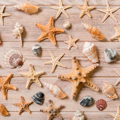 Fototapeta na wymiar Starfish and seashells background on a wooden table, top view, flat lay