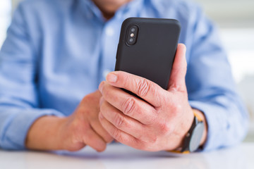 Close up of man hands using smartphone over white table